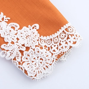 Elegant orange blazer with intricate white floral lace trim detail on the sleeve edge