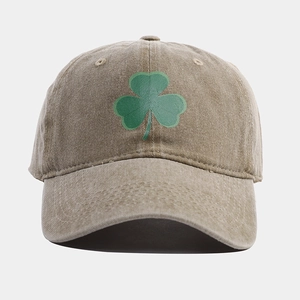 Dettaglio del cotone lavato kaki con ricamo a quadrifoglio verde sul berretto da baseball