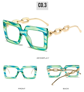 Detailed view of oversized green and blue marble glasses frames with gold chain temples