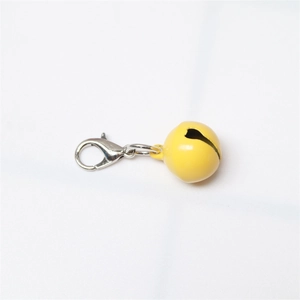 Close-up of a small yellow painted metal bell with a silver lobster clasp on white background