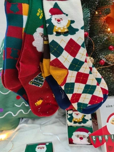 Detailed view of Christmas themed socks with Santa patterns in a festive green gift box