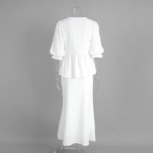 Detail view of the textured white fabric and ruffled hem on back of two-piece dress set