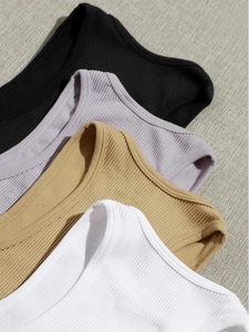 Detailed close-up of ribbed knit texture on slim-fit yoga vests in multiple colors