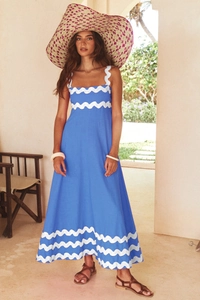 Detail of blue maxi dress with white rickrack trim and elegant sleeveless halter neckline