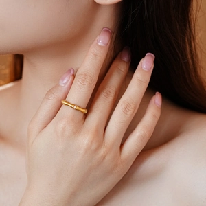 Detail of matte gold bamboo ring featuring sparkling cubic zirconia stones for women