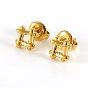 Close-up of golden grid-patterned stainless steel stud earrings on a white surface