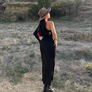 Detailansicht eines schwarzen One-Shoulder-Kleides mit Seitenschlitz und schmaler Passform