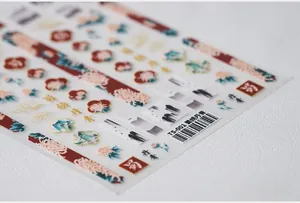 Detail of Chinese ink painting nail stickers featuring green landscape and gold accents