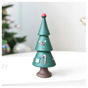 Detail of green resin Christmas tree figurine with embossed candy canes and gift boxes