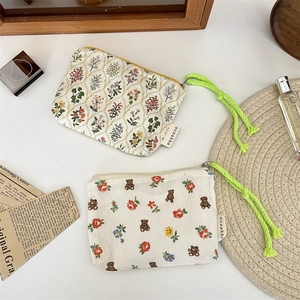 Close-up of two Korean style canvas makeup pouches with floral and bear patterns
