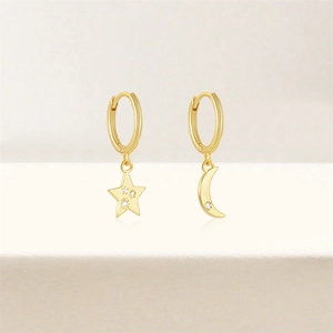 Detail of gold asymmetric S925 sterling silver hoop earrings with star and moon charms