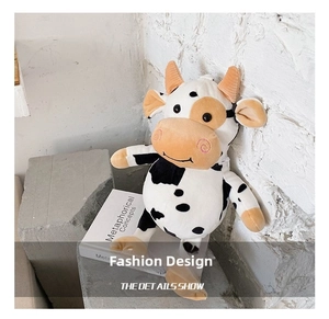 Detail showing the cute cow plush crossbody bag with black spots and orange horns