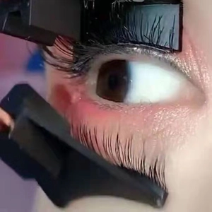 Close-up view of a professional magnetic eyelash applicator tool applying lashes on eyes
