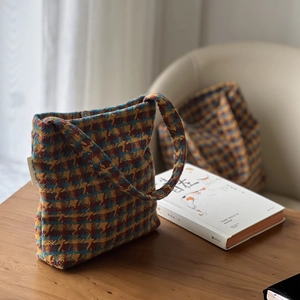 Close-up of retro knit shoulder bag featuring houndstooth pattern and magnetic metal clasp