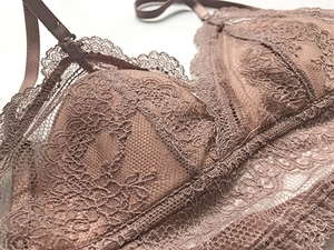 Gros plan sur la dentelle fine et les bords festonnés d'un soutien-gorge triangle marron