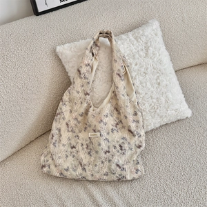 Detail view of lace trim and purple butterfly floral print on beige canvas tote bag