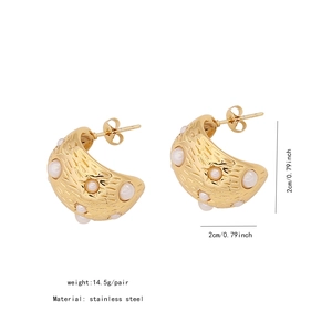 Detail of C-shaped stainless steel earrings with textured gold finish and faux pearls