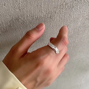 Detail of 925 sterling silver irregular hammered ring with minimalist texture on model