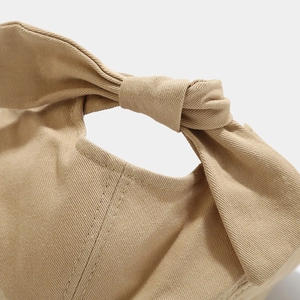 Detail of khaki canvas sun hat featuring a stylish rear bow tie and twill texture