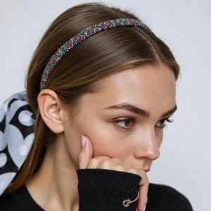 Minimalist rainbow beaded headband accessory worn by a model in a side profile view