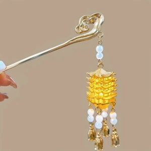 Detailed close-up of golden cloud pattern hair pin with pagoda tassel and white pearl charms