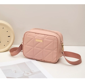 Detail of pink quilted pattern on PU leather bag with golden metallic hardware