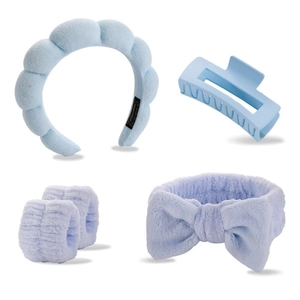 Detail of light blue spa headband set with wristbands and a bow on white background