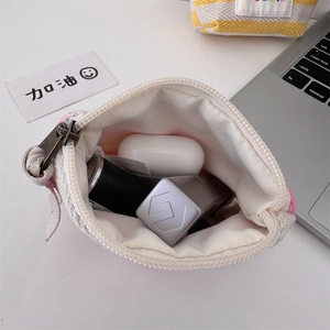 Close-up of pink knitted pouch showing metal zipper and internal storage space