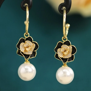 Detail of luxury drop earrings with black camellia flower, zircon stones and round pearl