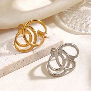 Minimalist crisscross open rings in gold and silver finish on elegant silk background