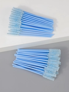 Close-up of disposable light blue mascara wands with spiral nylon bristles and plastic rods