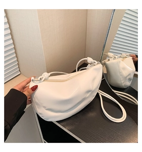 Detail of white crescent shoulder bag with knot strap and matte leather texture