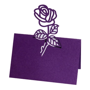 Macro shot of laser-cut purple rose floral design on premium paper wedding place card