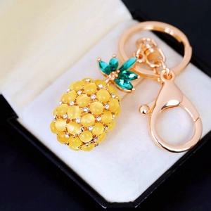 Elegant gold-plated pineapple keychain with yellow cat-eye stone and crystal accents