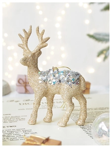 Detail of a gold Christmas reindeer ornament with silver sequins and festive bokeh background