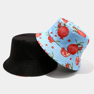 Detail of reversible bucket hat showing black solid side and blue pomegranate print side