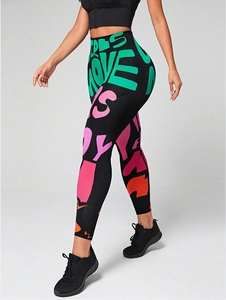 Detail of high-waisted yoga pants with colorful graffiti print and ribbed texture fabric