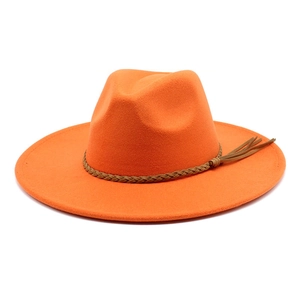 Close-up of bright orange wide-brim felt fedora with woven brown cord and fringe detail