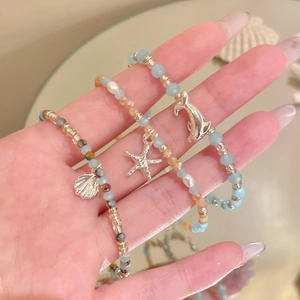 Nahaufnahme von sommerlichen Perlenarmbändern mit Seestern- und Delphinanhängern