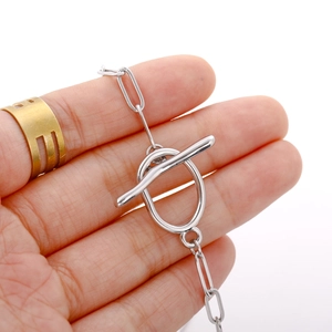 Minimalist silver stainless steel chain with OT toggle clasp held in hand close-up