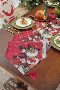 Detailed view of a red Christmas table runner with snowman patterns and fringe tassels