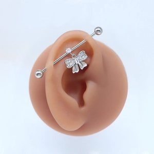 Silver butterfly industrial barbell earring with rhinestones on a silicone ear model
