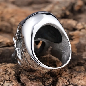 Gothic long-toothed zombie skull ring in silver stainless steel on rustic bark