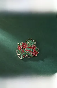 Detail view of 4.3cm Christmas bell brooch with red enamel flower and gold finish