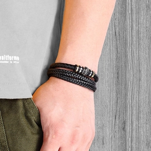 Close-up of a multi-layer black braided leather bracelet for men on a model's wrist