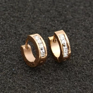 Macro shot of rose gold titanium earrings with sparkling crystals on black background