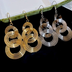 Detailed view of layered gold and silver metallic coil earrings with elegant hook style