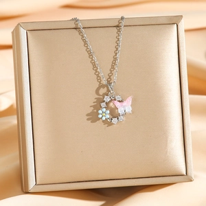 Collier pendentif papillon avec perles et zircons sur fond de soie dorée