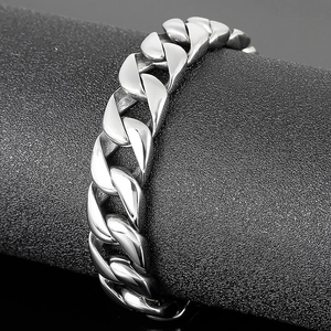 Detailed close-up of a silver Cuban link bracelet with high-polish stainless steel finish