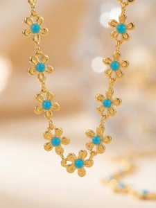 Détail du collier à fleurs dorées avec perles turquoise bleues et placage or 18k